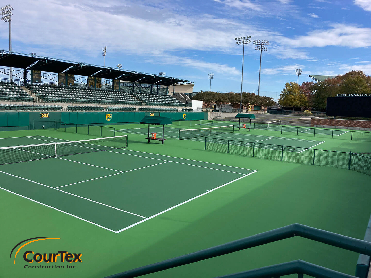 Luxury tennis courts with premium surfacing, stadium-style bleacher seating, and professional lighting for an elite playing experience.